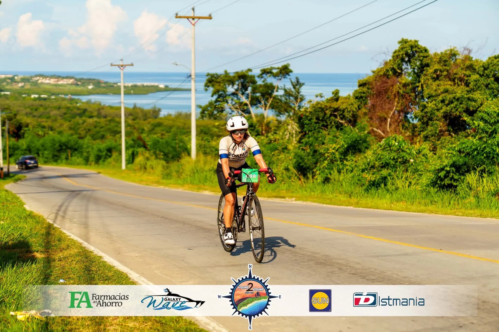 Roatán Point 2 Point — ciclista ruta mujer dorsal 98 subida oceano.