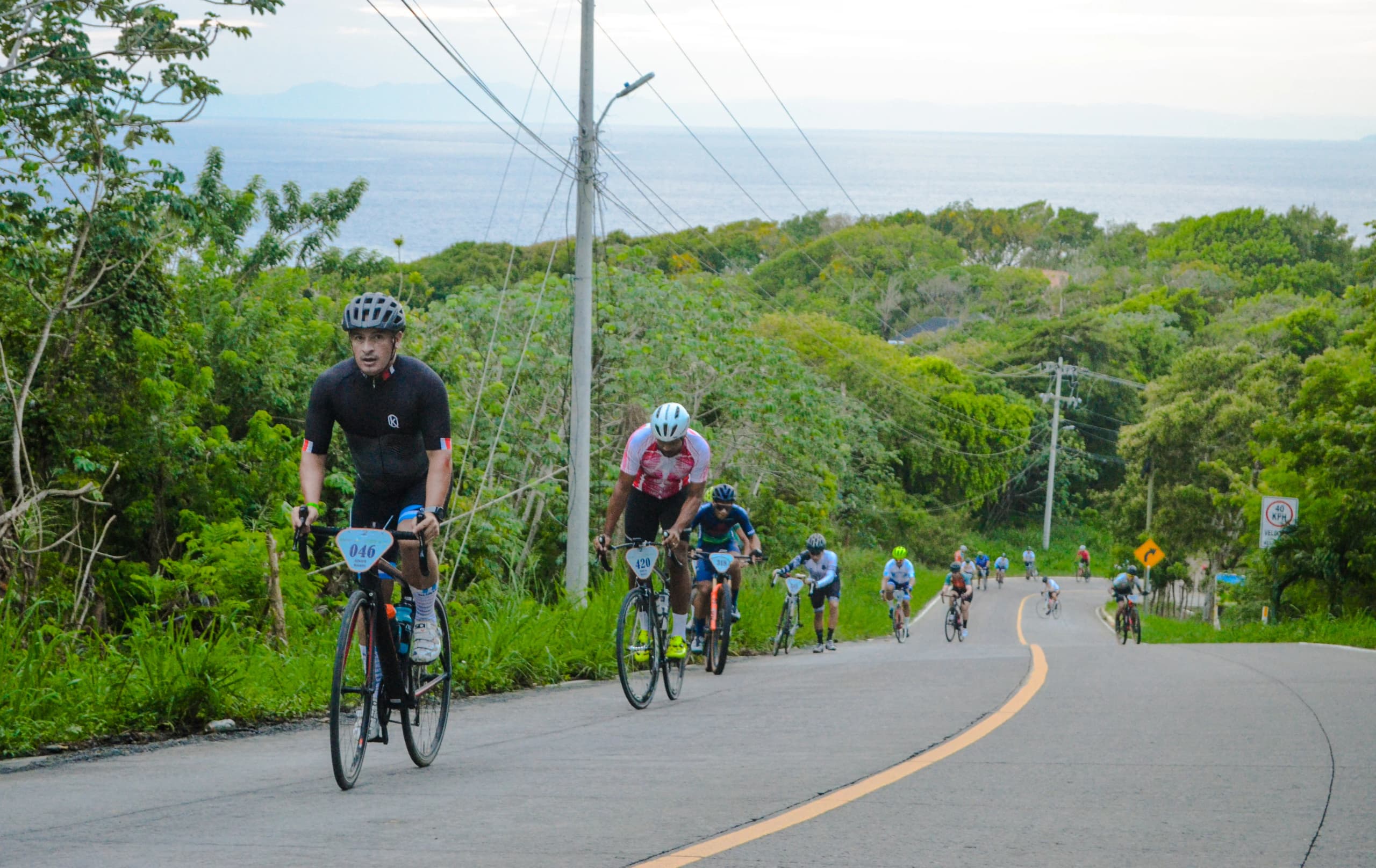 Roatán Point 2 Point — grupo ciclistas subida carretera costera. Fotografía Adonis Maradiaga.